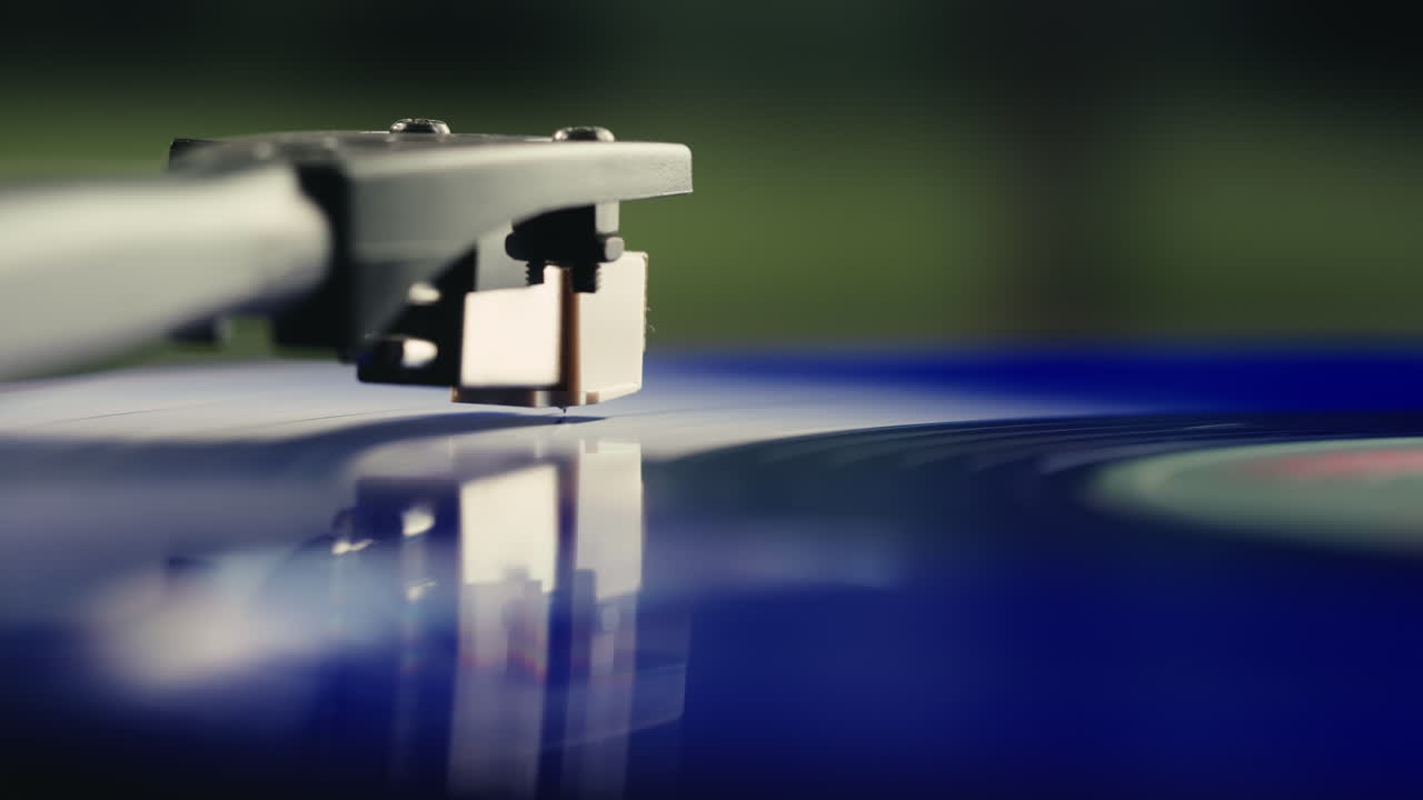 Primo piano di una puntina del giradischi che riproduce un disco in vinile blu