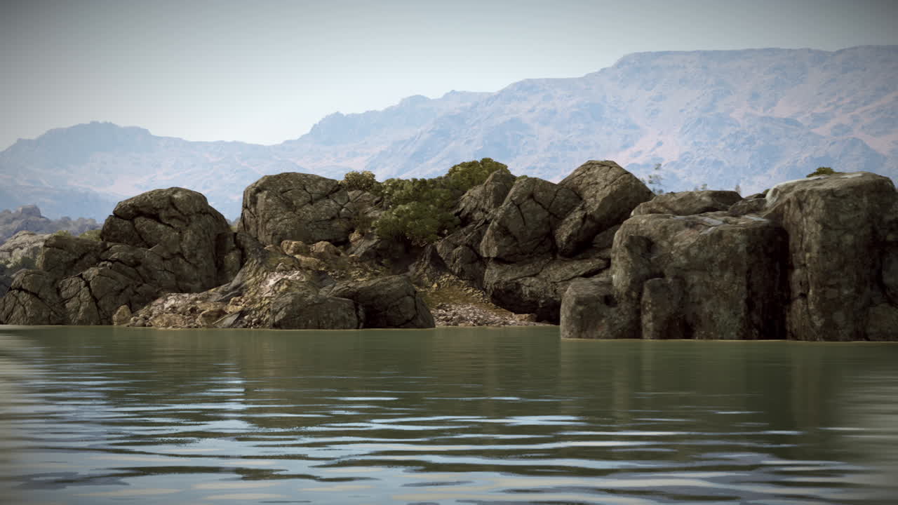 Rugged rock formations surrounded by calm waters at sunset near the mountains