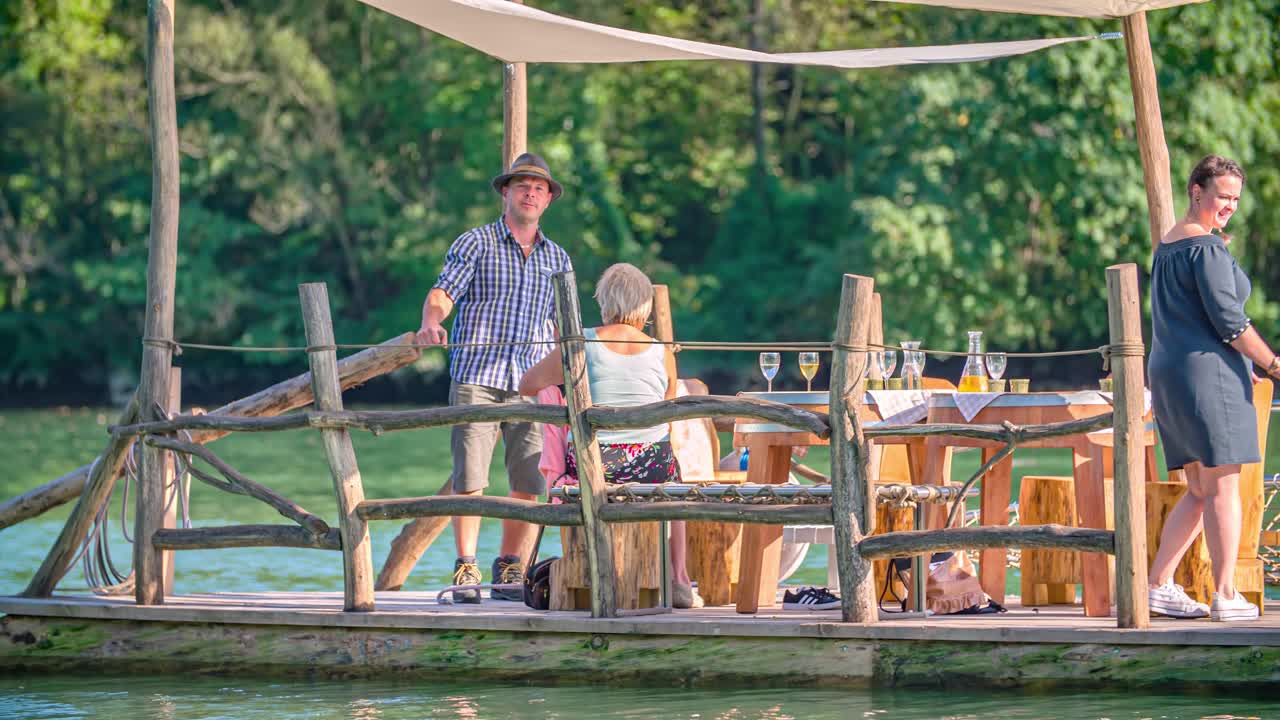 Caucasian Family Enjoys Summer Afternoon Cruising Along on wooden Raft