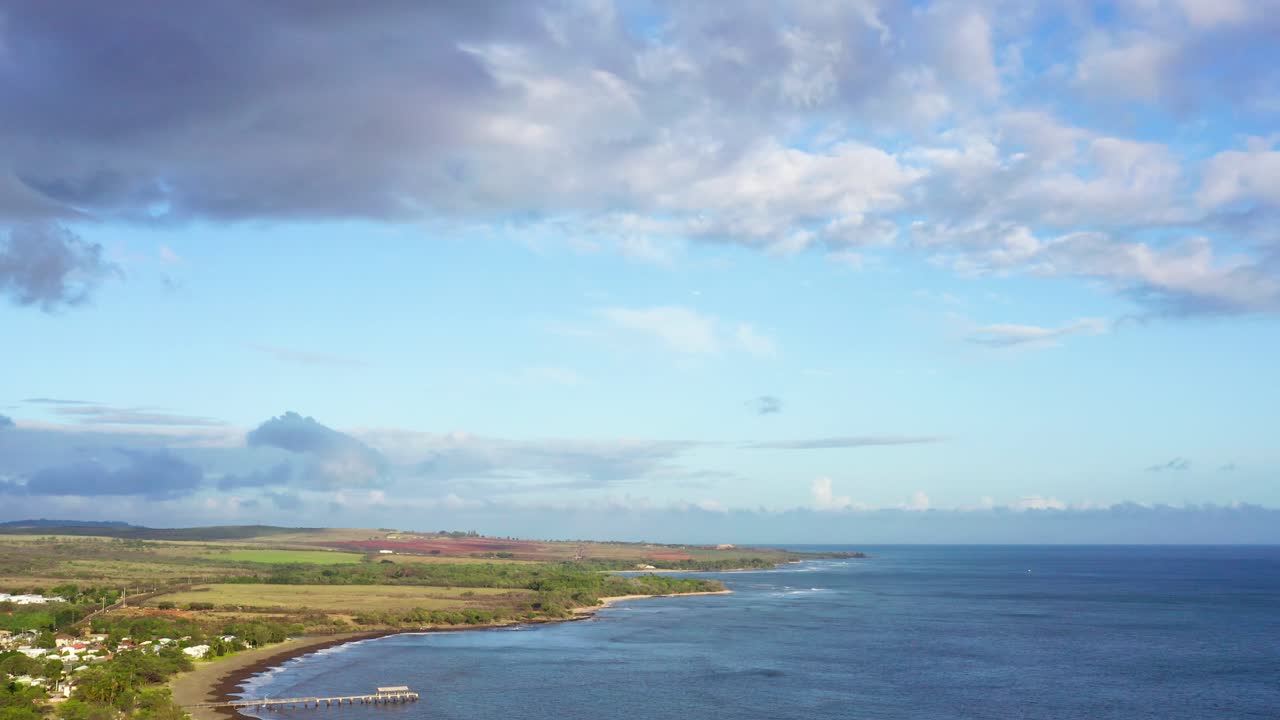 Epic long drone shot of Waimea Bay in Waimea, Kauai, Hawaii. Filmed in 4K aerial slowly tilts down from the clouds at sunset revealing the golden beach and tranquil waves
