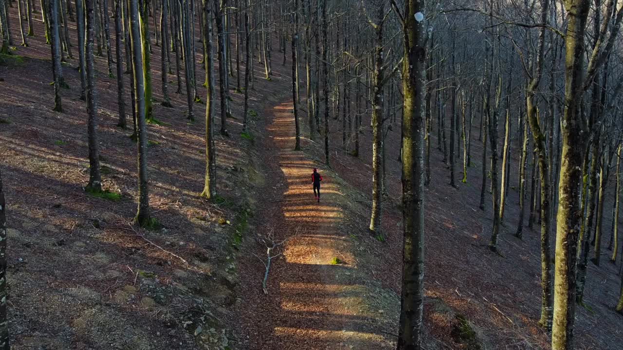 hombre corriendo y practicando senderos corriendo por el bosque en invierno