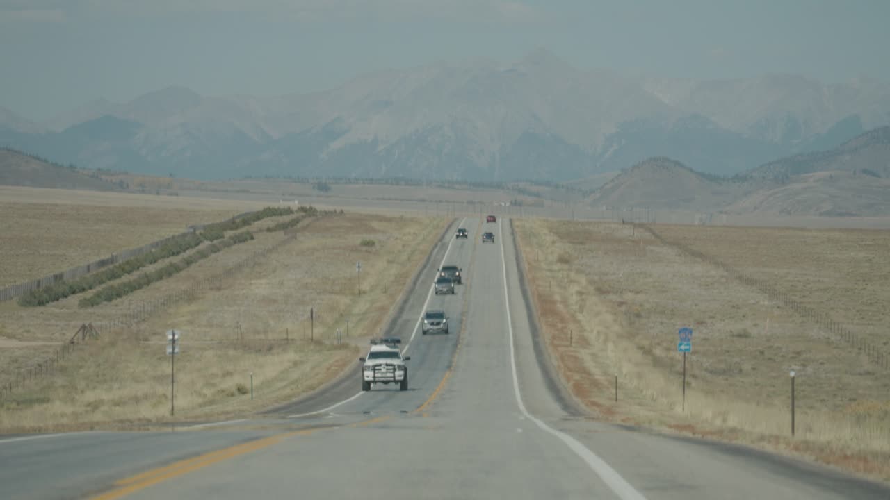 coches en una carretera con montañas en el fondo