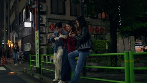 friends enjoying nighttime street food in japan