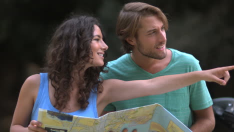 una pareja leyendo un mapa y sonriendo.