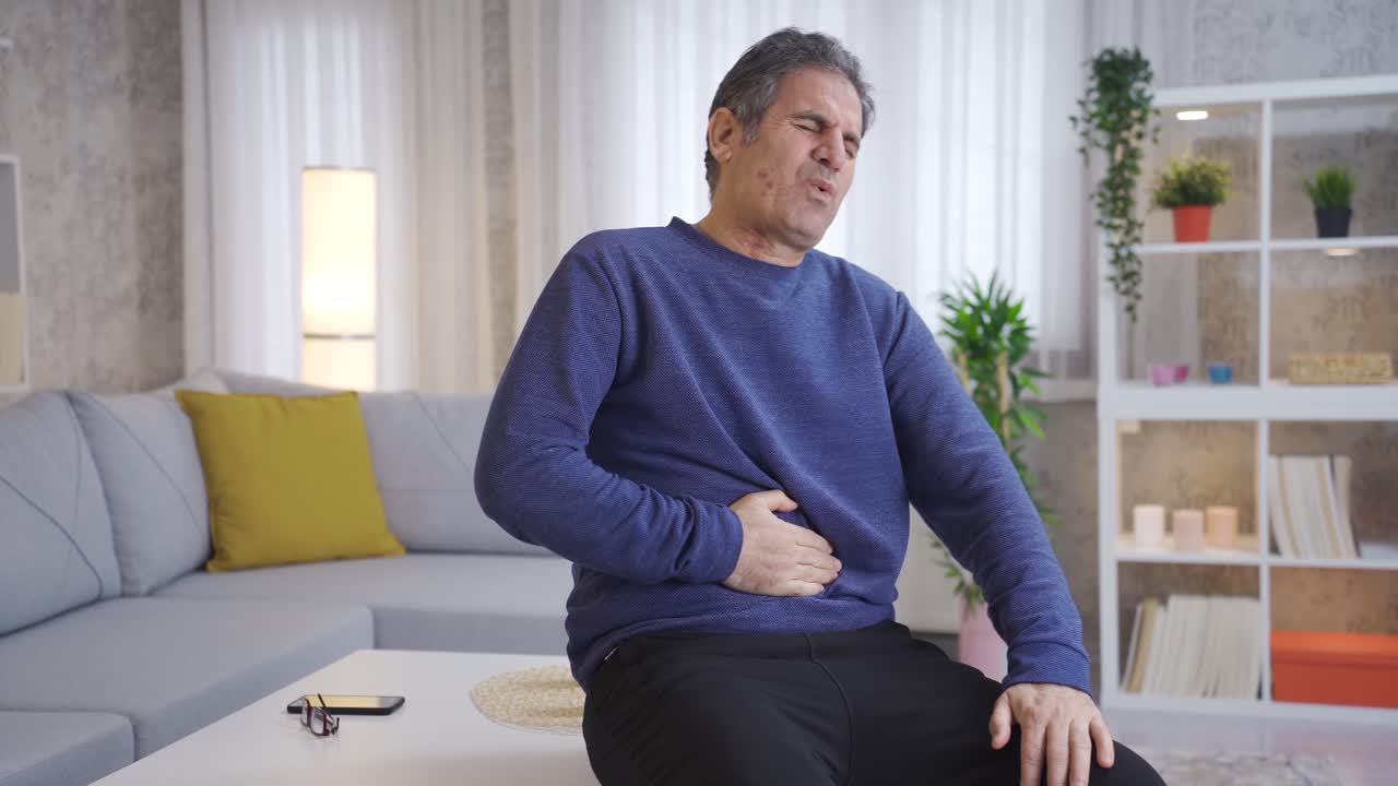 Mature man has stomach ache.