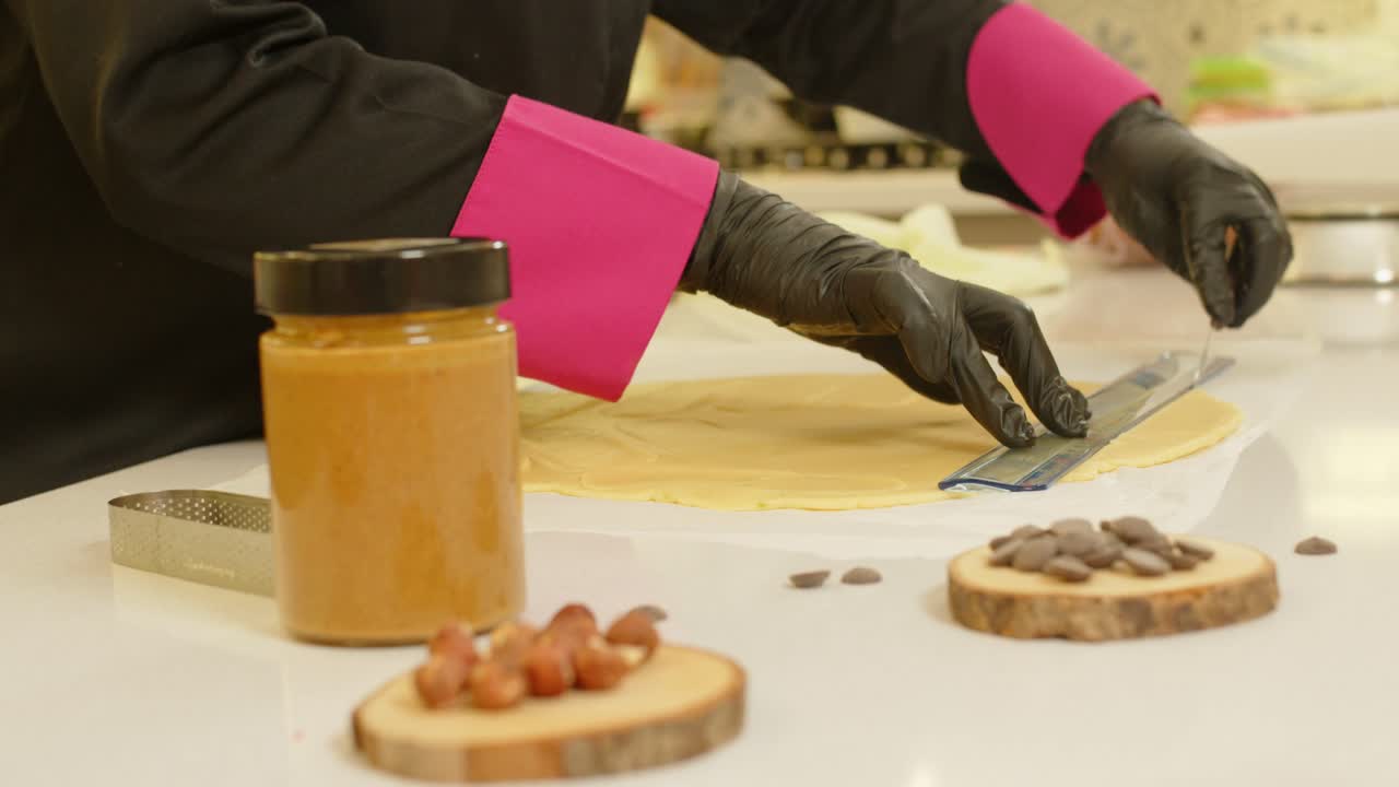 Scena in cucina con le mani dello chef che tagliano impasto crudo