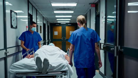hospital staff moving patient on stretcher in corridor