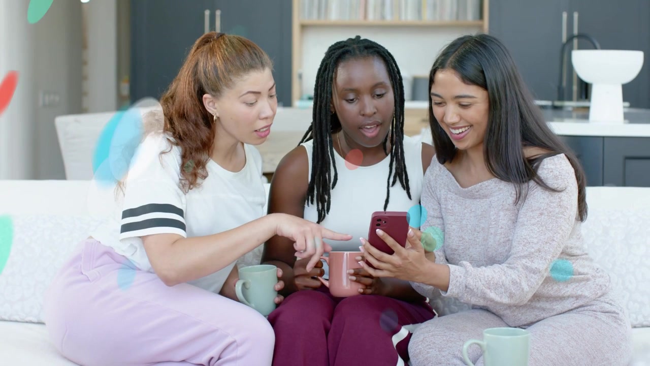 Three pals on sofa, center showing phone for social, leaning, pointing, with mugs, overlay drifting