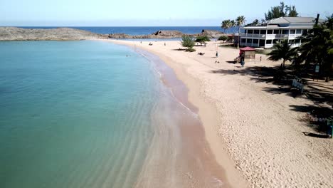 DRONE-BEACH-TAKE-OF-CRYSTAL-CLEAR-BLUE-WATER-BEACH-WITH-PALM-TREES-AND-PEOPLE