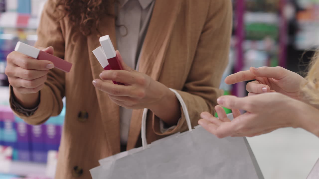 Female Customers Testing Lipsticks In Cosmetics Store