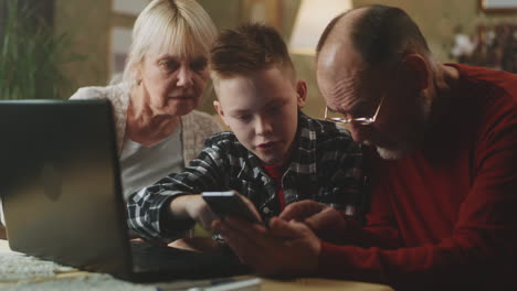 abuelos y nietos usando tecnología juntos
