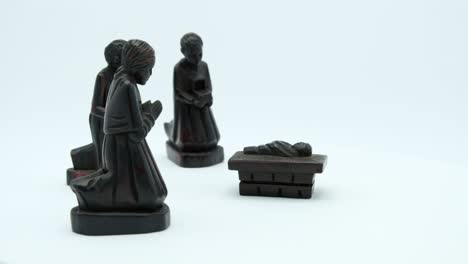 dark wood christian nativity scene of jesus and the three biblical magi.