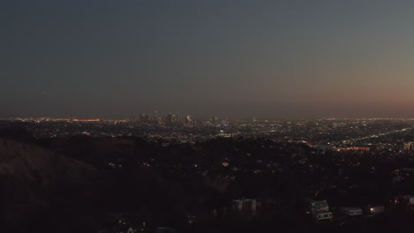 AERIAL:-Over-Hollywood-Hills-at-Night-with-view-on-Downtown-Los-Angeles-view