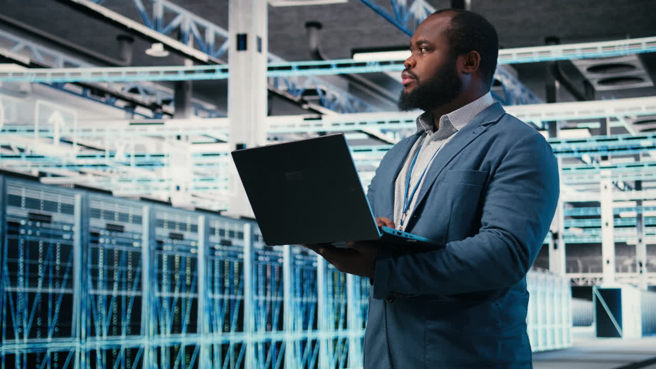 African American IT Professional Working on Laptop in Server Room