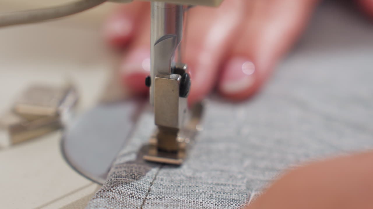 Close up view of needle passing through textile, capturing precise stitching moment, highlighting craftsmanship, detailing tension control, ensuring accurate seam alignment for professional finishing