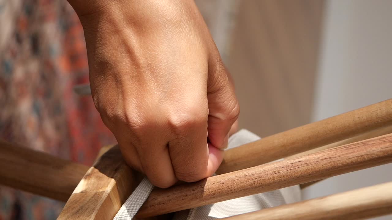 Close-up of a hand working on wooden furniture
