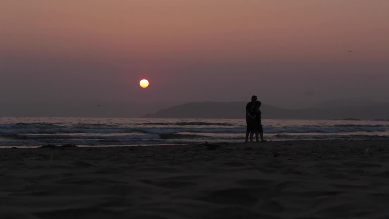 Romantic Couple Silhouette at Sunset on a Beach