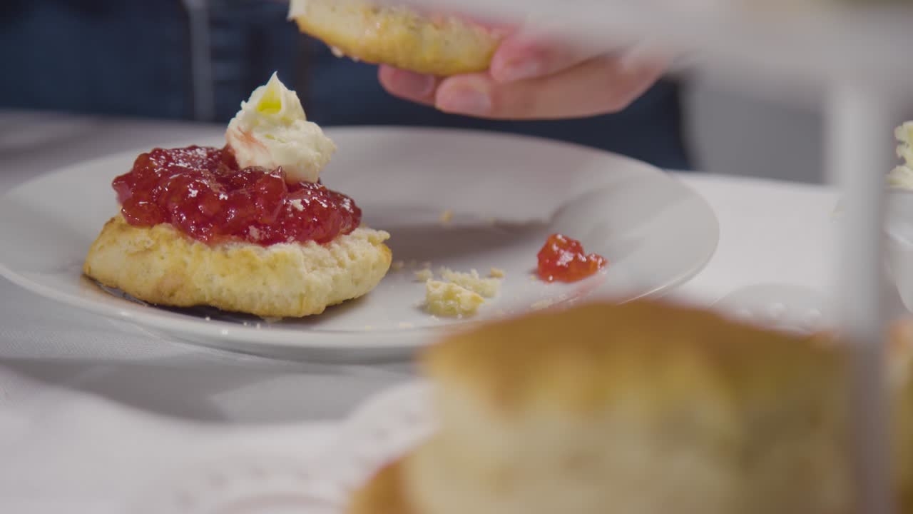 Close Up Shot Of Person With Traditional British Afternoon Tea With Scones Cream And Jam 3
