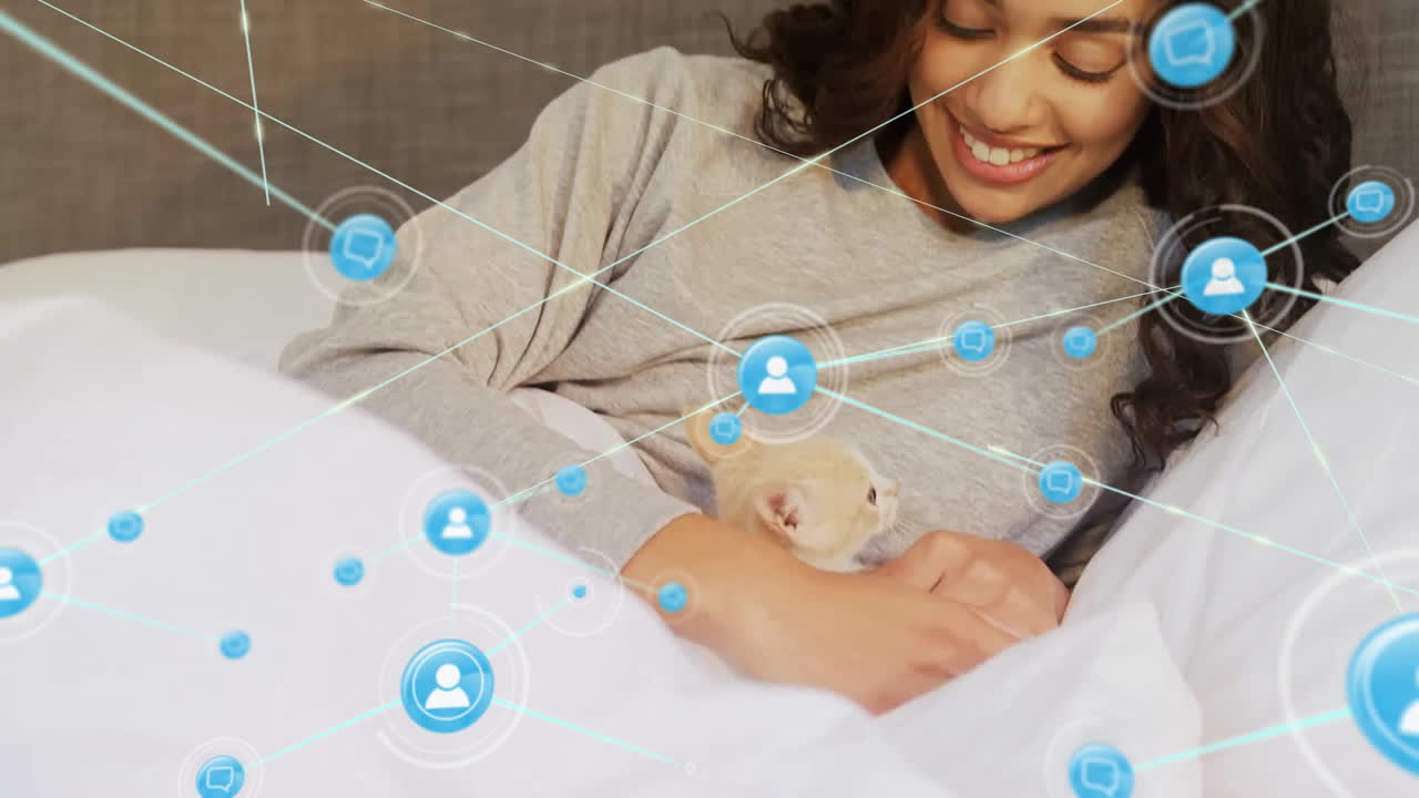 Animation of network of connected icons in circles over happy biracial woman petting pet cat