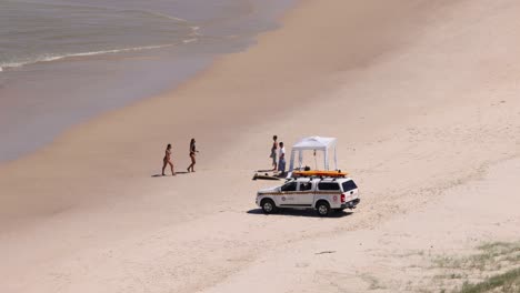 lifeguard vehicle and people on a sandy beach