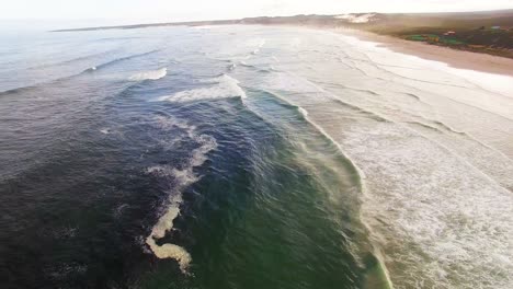 aerial view of waves reaching a shore at beach