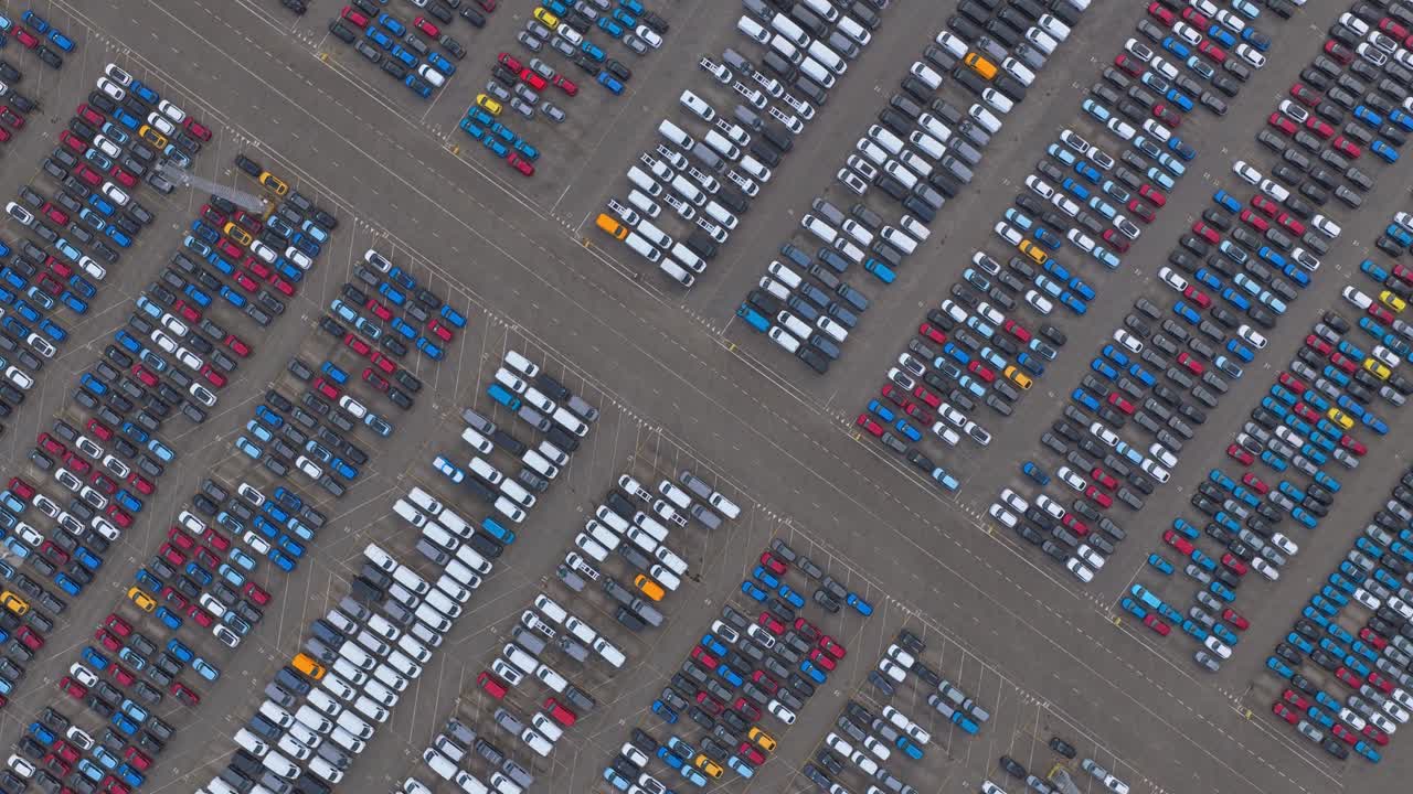 Droneoptagelse af bilindustriens havneterminal med farverige køretøjer