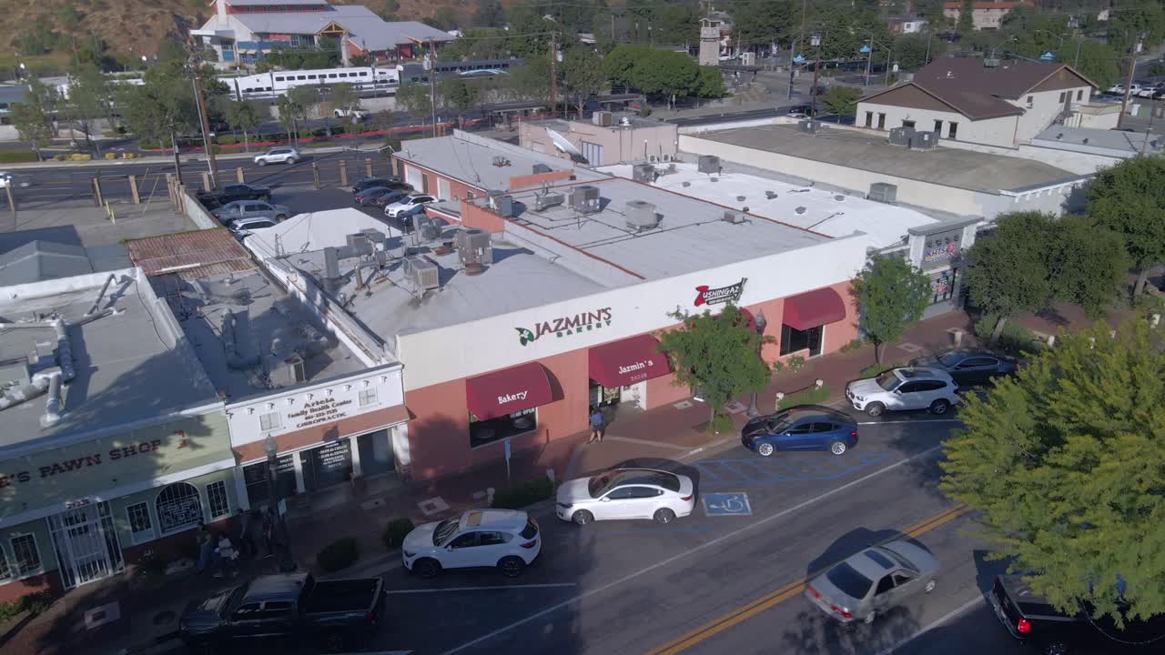 Aerial view flying in front of stores in downtown Valencia, sunny day in CA, USA