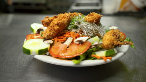 ensalada de tiras de pollo frito se sienta en el pase, verduras y verduras cubiertas con pollo, diapositiva hd