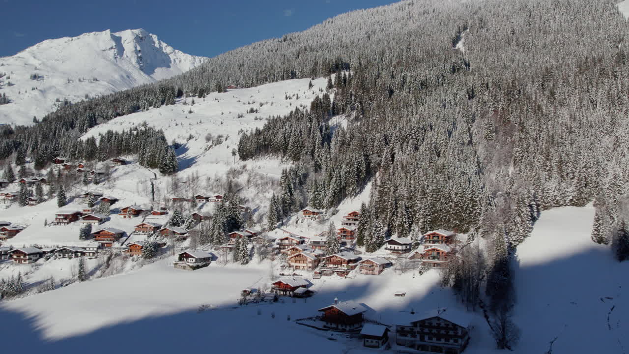 vista aérea de casas de vacaciones, bosque de pinos y montañas en invierno en langau, austria