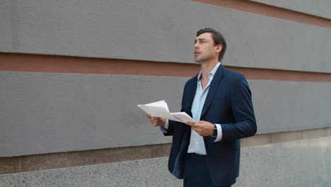 serious business man reading documents. man walking with documents at street