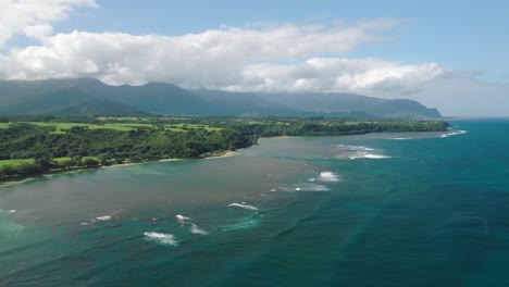 wide aerial shot tracking right away from the coast at anini beach, kauai, hawaii