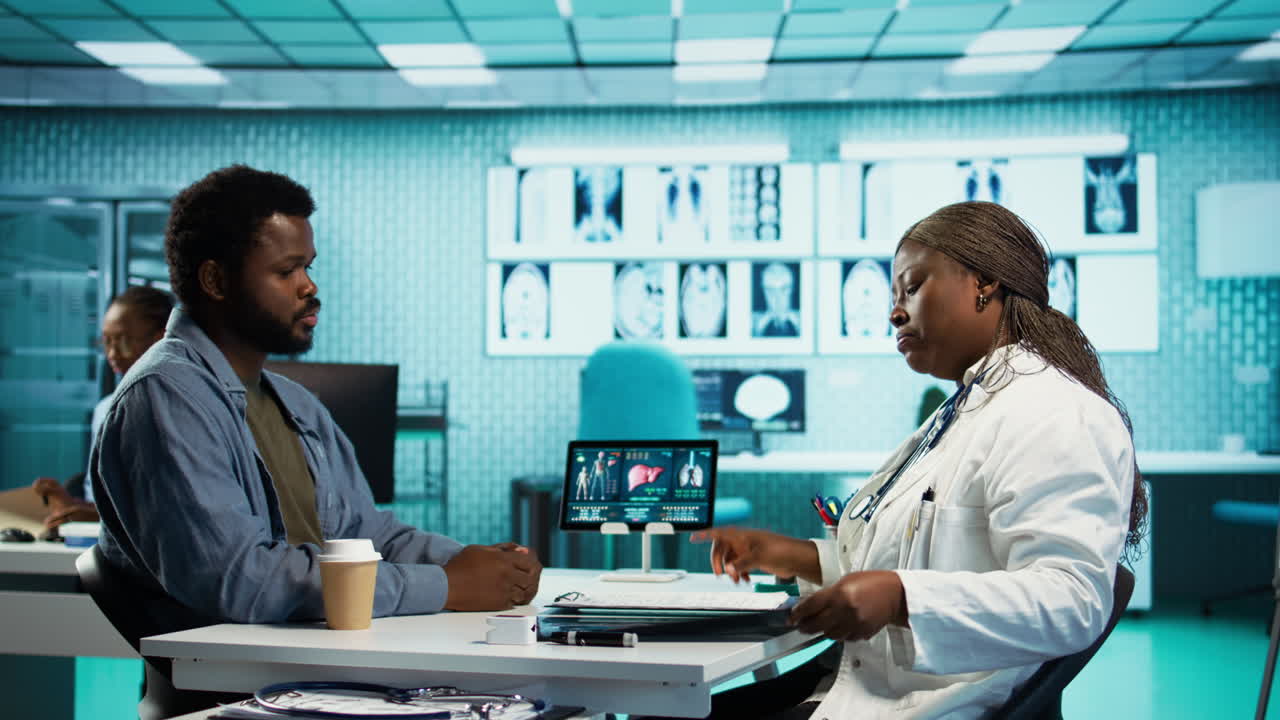 General practitioner reviewing x ray imaging at checkup with male patient