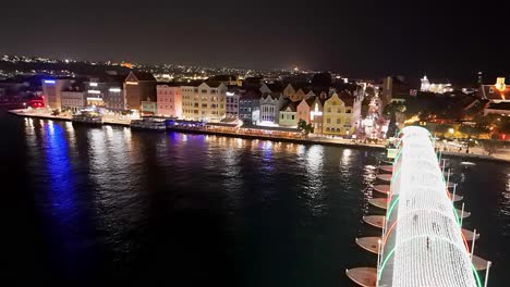 Panorama-Dolly-Aus-Der-Luft-über-Den-Feiertagslichtern,-Die-Sich-Auf-Dem-Wasser-Der-Handelskade-Curacao-Spiegeln