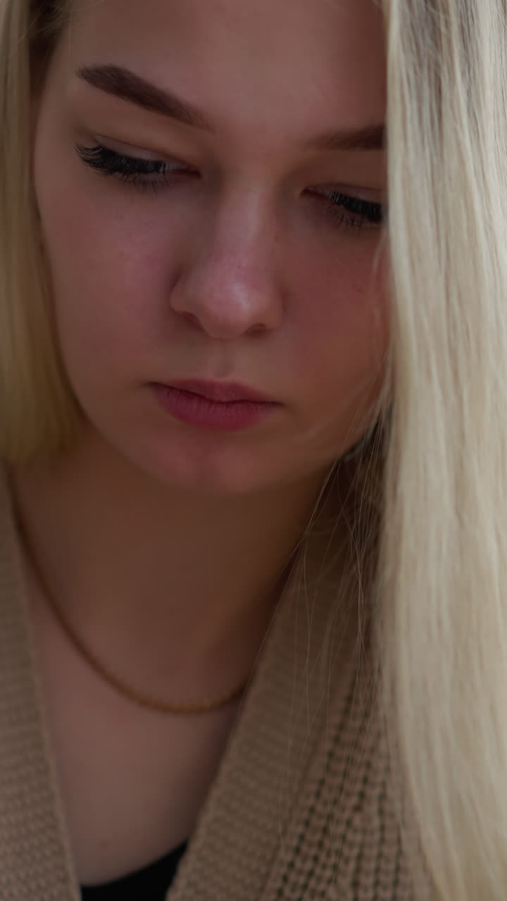 냉정한 여인은 펜으로 글을 쓰는 데 깊이 집중하고, 그녀의 긴 머리카락은 어깨를 가로질러 떨어지고, 그녀의 목에는 섬세한 목걸이가 앉아 있으며, 그녀는 그녀의 일에 집중합니다.