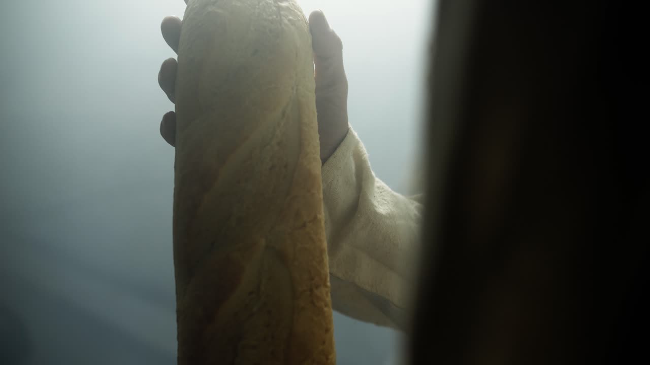 Closeup of Jesus Christ holding bread in glowing bright light, representing Jesus as the bread of life, the gospel, forgiveness, and salvation. Perfect for Easter Sunday visual or worship background.