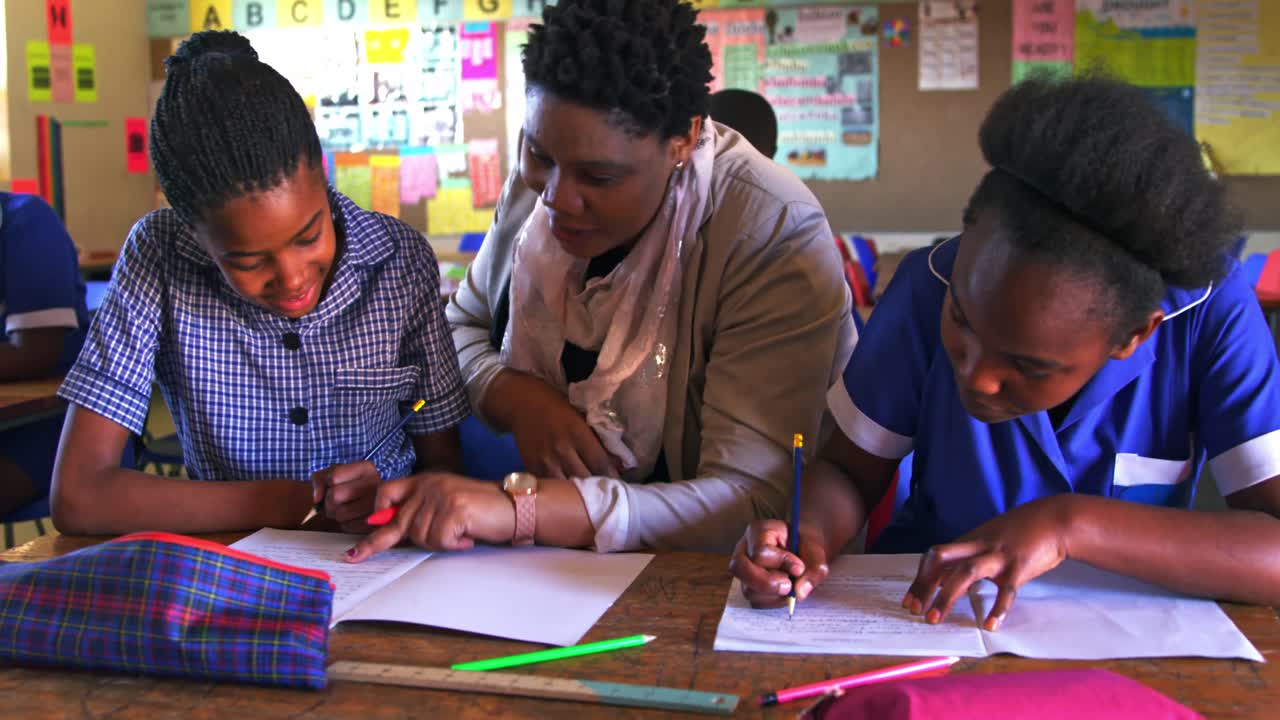 Teacher helping schoolchildren in a lesson at a township school 4k