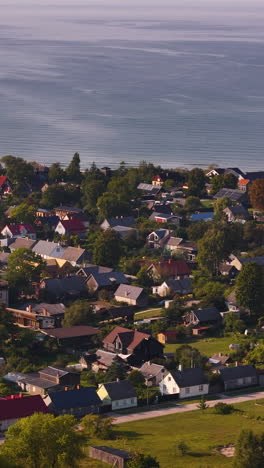 vertical aerial view of pavilosta, forested summer town next to baltic sea in latvia