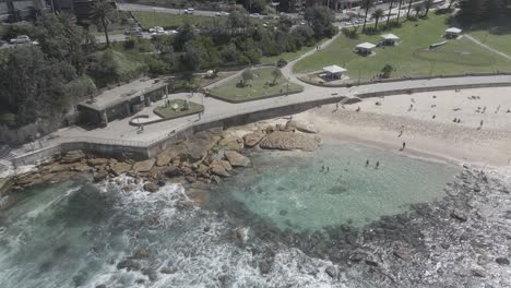 Bondi-to-Bronte-Ocean-Swim---People-On-Rocky-Seashore-Near-Bronte-Baths-In-Eastern-Suburbs,-Sydney-NSW,-Australia