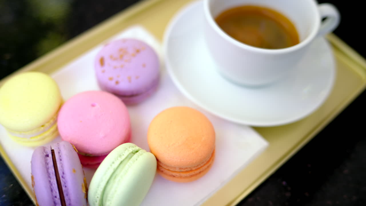 Colored french macarons with a cup of black cofee
