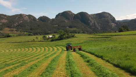 Statischer-Schuss-Eines-Traktors,-Der-Gras-Auf-Einem-Feld-Auf-Einem-Bauernhof-In-Ländlicher-Natur,-Norwegen,-Erntet