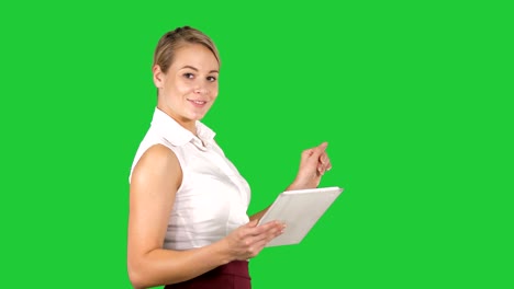 female office clerk walking with tablet and smiling broadly when talking to camera on a green screen, chroma key