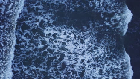 aerial bird's eye view of sea waves passing by