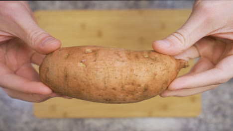 primer plano de un hombre que sostiene una batata