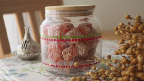 glass jar of candied fruit with dried plants