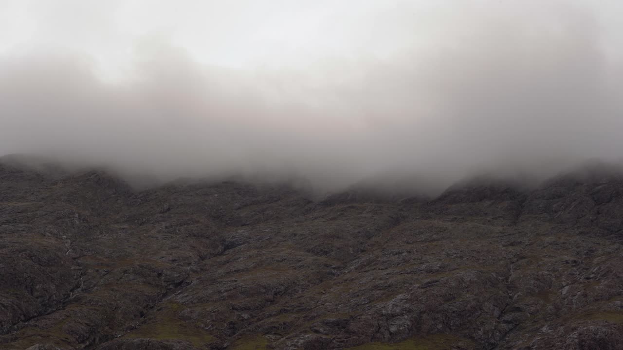 낮은 구름에 덮인 안개 낀 산을 올려다보며