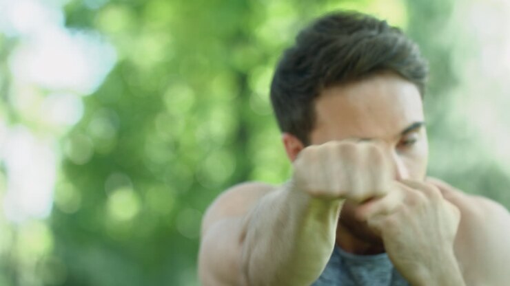 Male boxer training in park