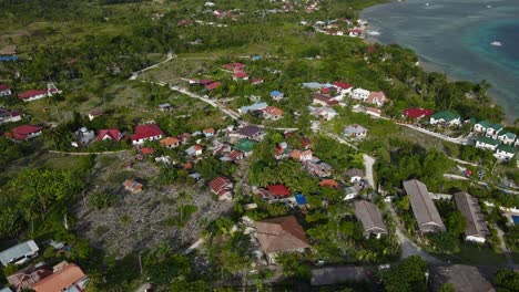 Moalboal,-philippines-showcasing-coastal-town-and-lush-surroundings,-daylight,-aerial-view