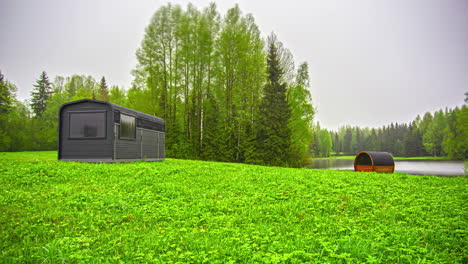 Thermalholzhütte-Mit-Thermoholzfasssauna-Auf-Grüner-Landschaft-Bei-Nebligem-Sonnenaufgang