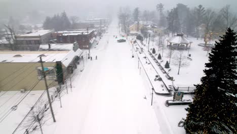 snow-plow-on-main-street-in-blowing-rock-nc,-north-carolina-aerial-in-snow-storm-near-boone-nc,-north-carolina