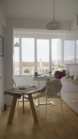 frau arbeitet von zu hause aus in einer küche